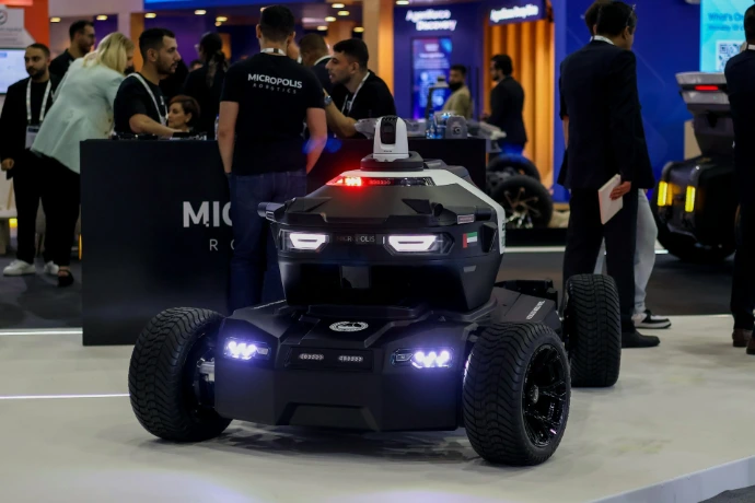 A futuristic security robot with flashing lights on display.